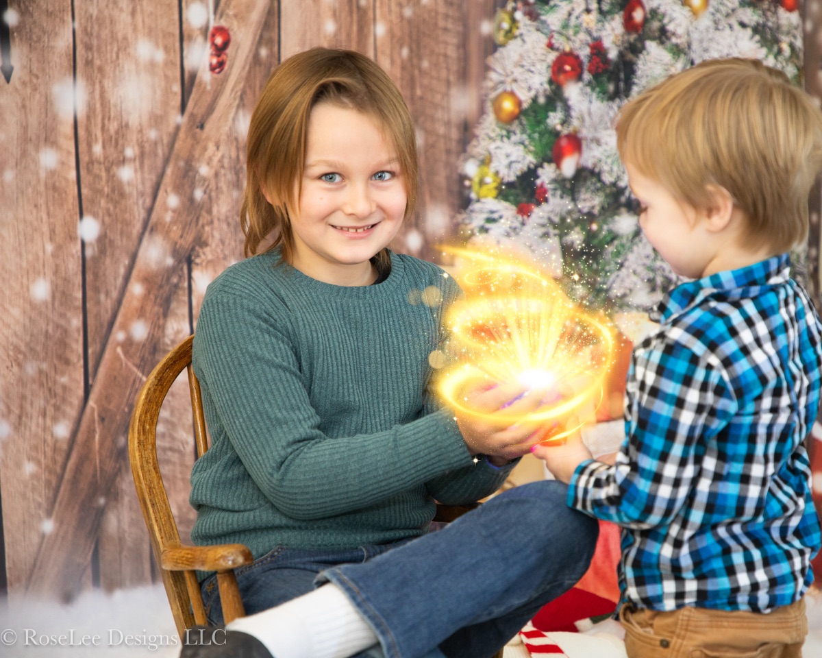Children holding a glowing golden orb in a Christmas portrait