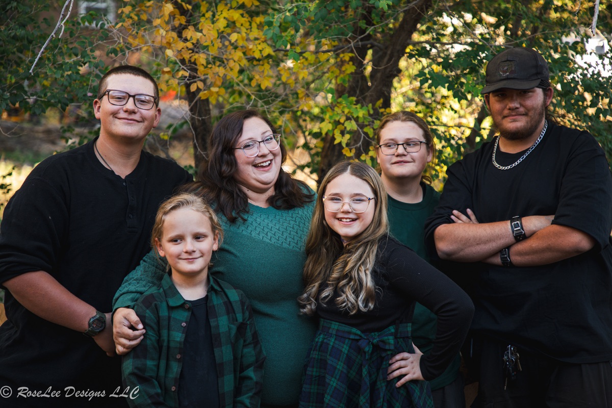 Family sharing a laugh beneath leafy trees