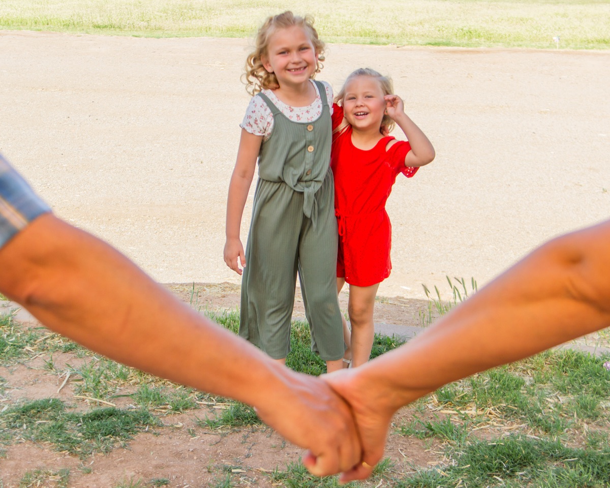Two children framed by the joined hands of adults