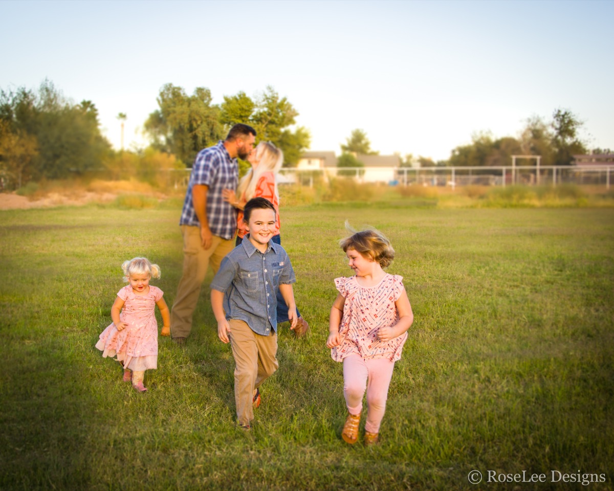 Family walking together through a sunlit green field