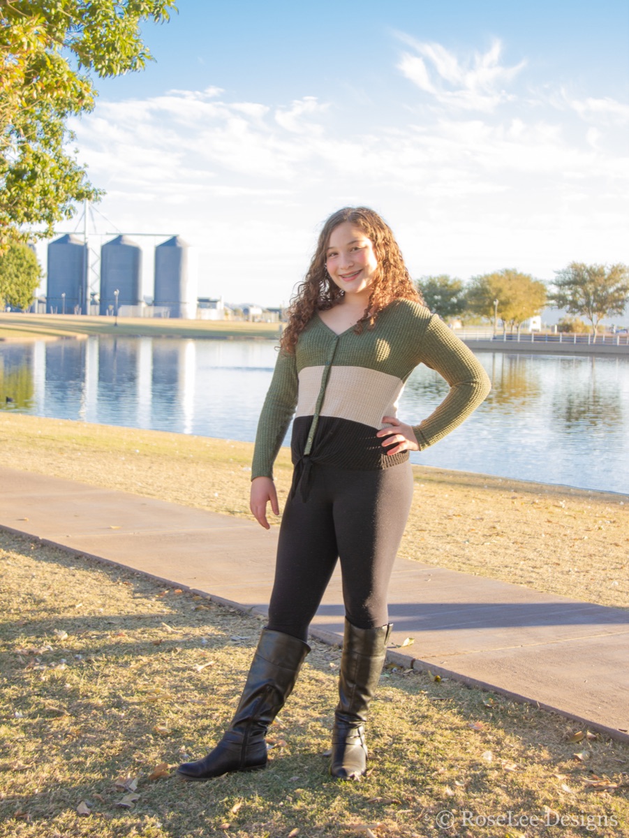 Young woman standing beside a sunlit lake