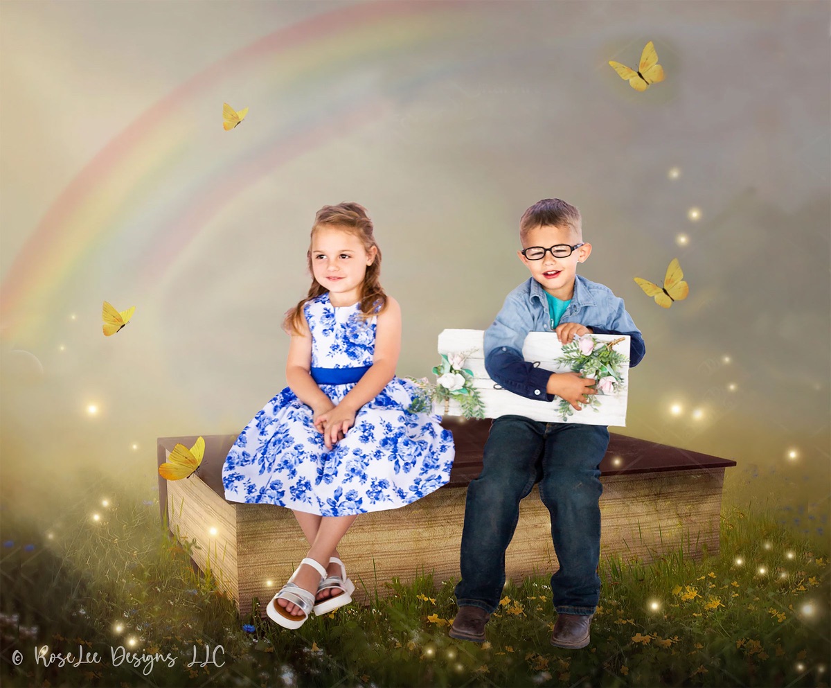 Creative portrait of two children beneath a rainbow with butterflies