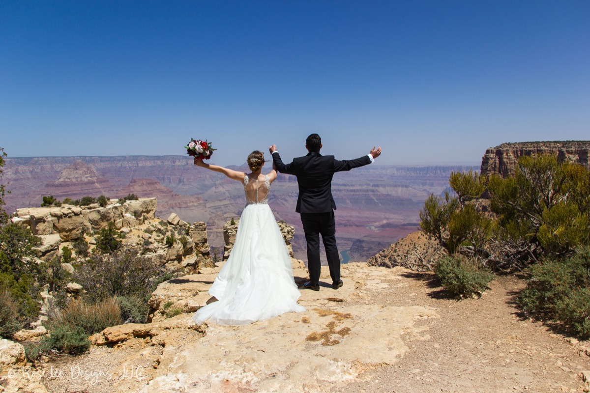 Newlyweds celebrating with open arms above the Grand Canyon